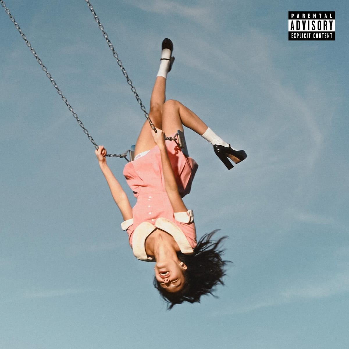 Cover art for Olivia Rodrigo's latest album, a photo of her swinging in a park swing against a blue sky. She wears a pink dress and is upside down from the viewer perspective